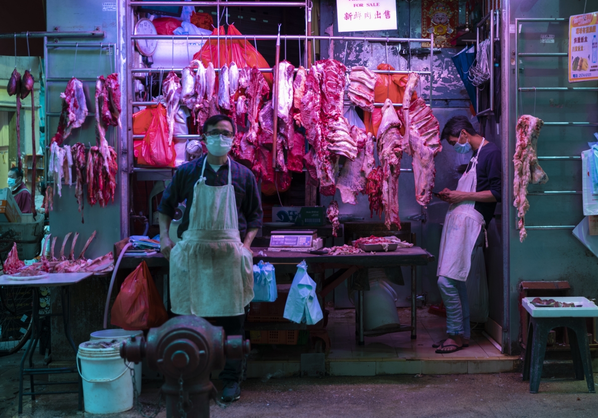 Butchers wait for customers at a wet market in Wanchai, Hong Kong.