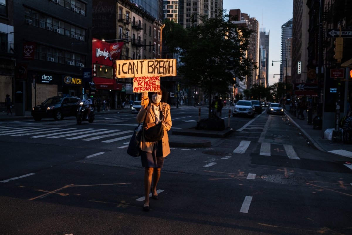 A woman displays her protest sign on 8th Avenue near Columbus Circle in Manhattan on June 6, 2020. 