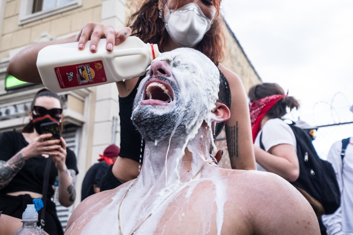 A man has milk poured into his eyes after being pepper sprayed by police during a protest in Flatbush, Brooklyn, on May 30, 2020. 