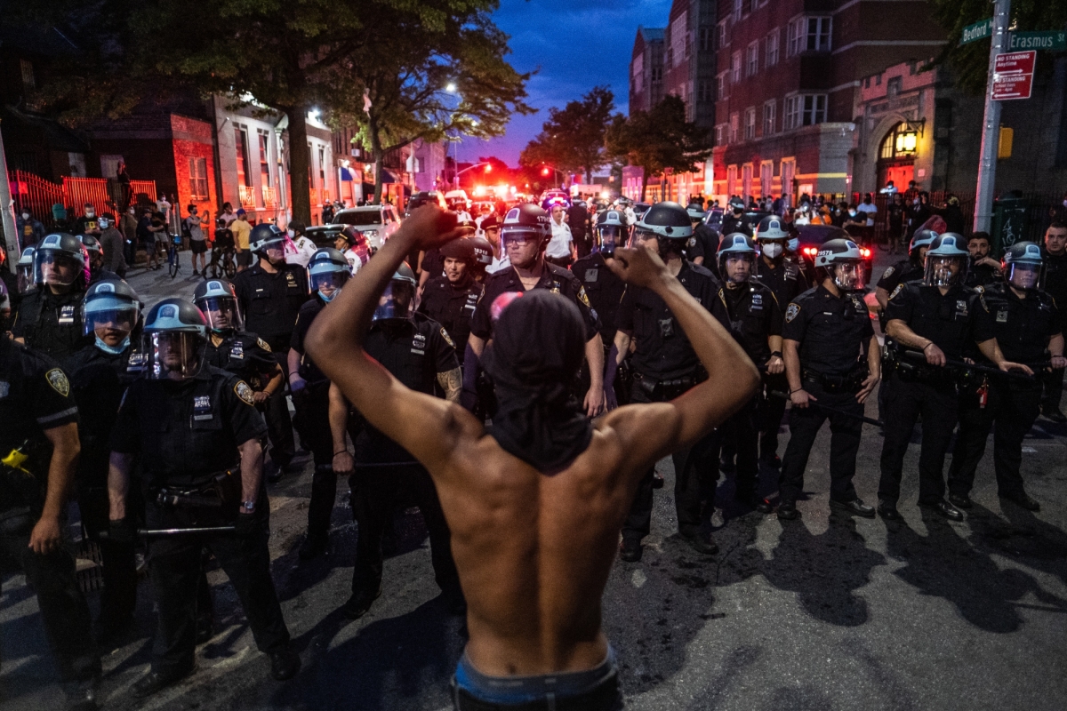 A protester stands in front of a group of NYPD officers in Flatbush, Brooklyn, on May 30, 2020. 