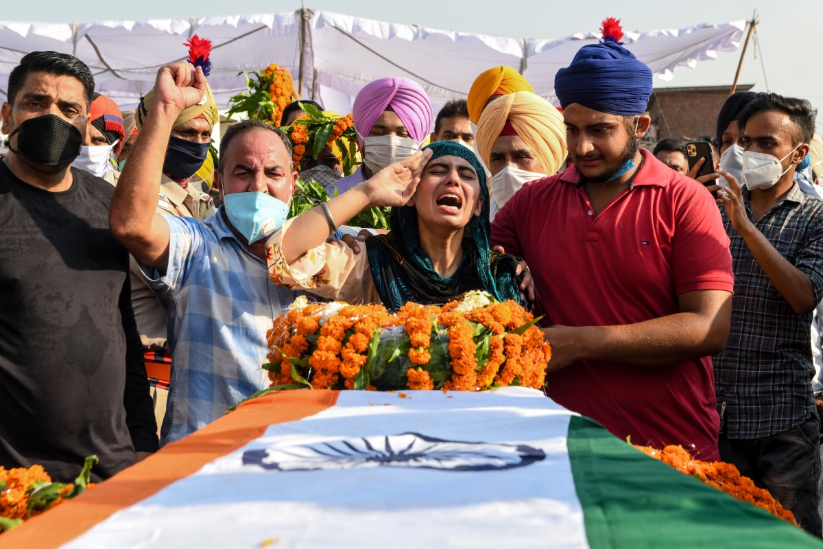 Sandeep Kaur (C) and her brother Prabhjot Singh (2R) react after laying the wreaths of flowers on the coffin of their father and soldier Satnam Singh who was was killed in a recent clash with Chinese forces in the Galwan valley area, during the cremation ceremony at Bhojraj village near Gurdaspur on June 18, 2020.