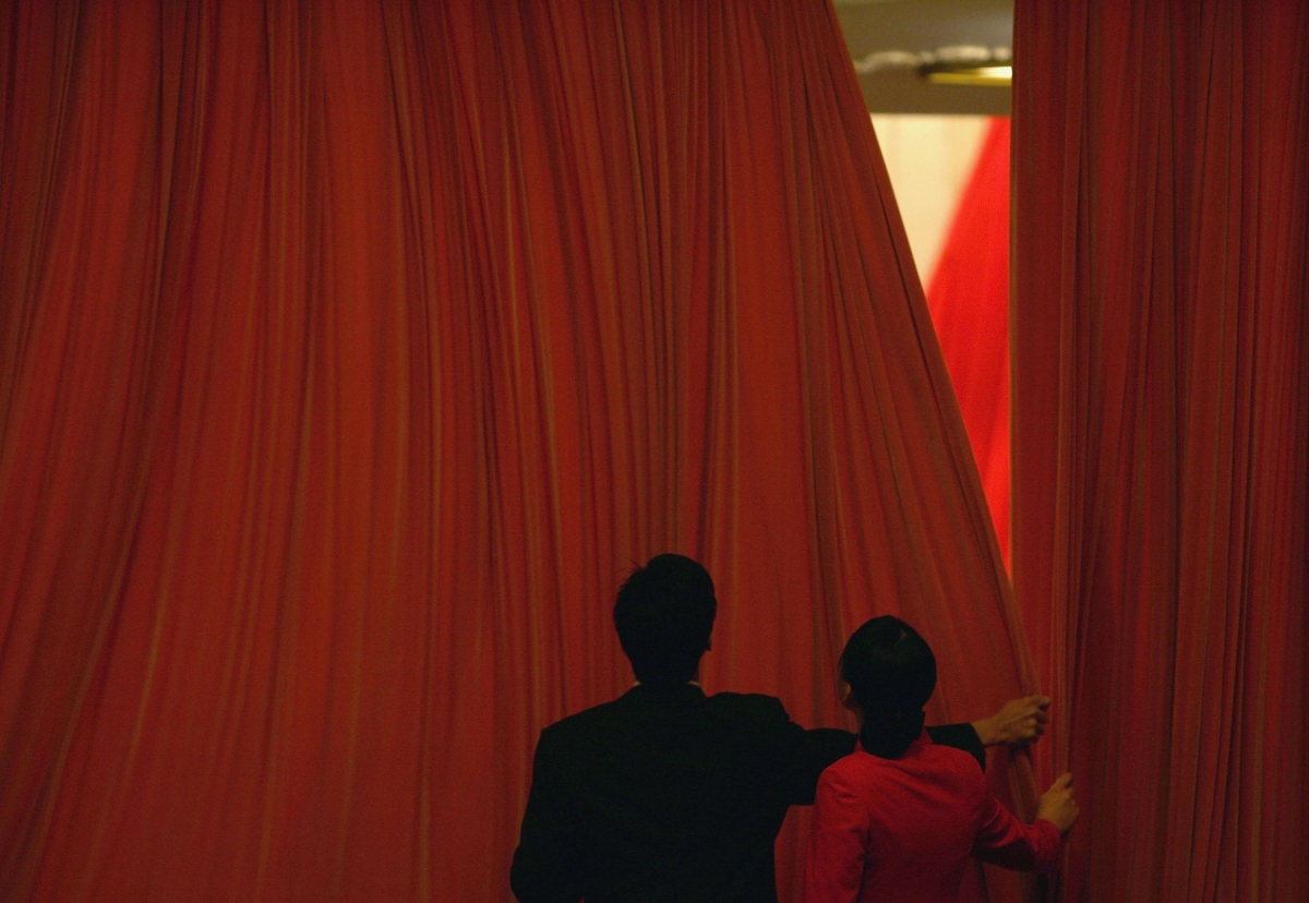 Chinese attendants close the curtains during the closing ceremony of the National People's Congress (NPC), or parliament, at the Great Hall of the People on March 14, 2005 in Beijing, China.