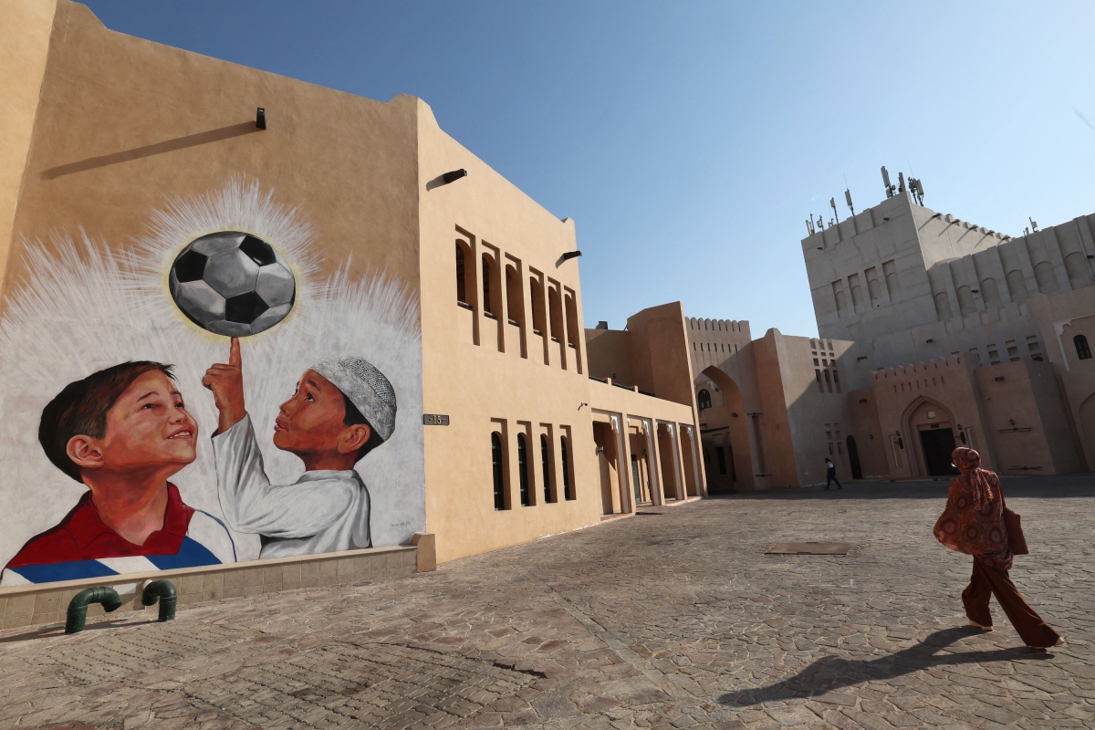 A woman walks past a mural in the Katara Cultural Village in Qatar's capital Doha, on October 11, 2022, ahead of the FIFA 2022 World Cup.