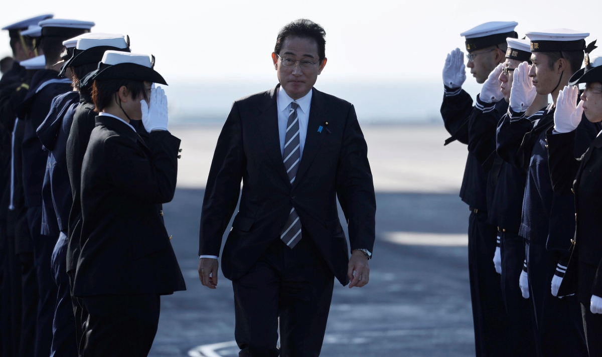 Japanese Prime Minister Fumio Kishida is saluted by members of the Japan Maritime Self-Defence Force