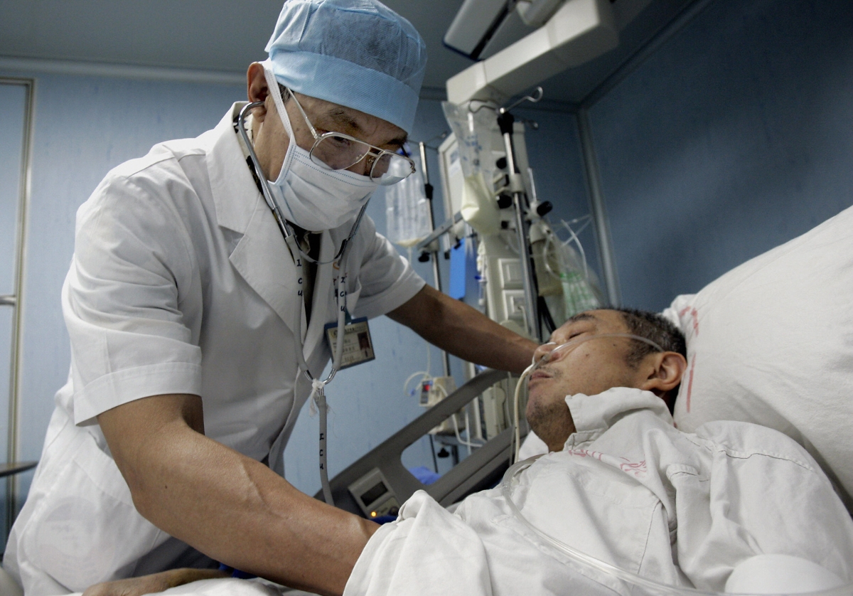 China's top Severe Acute Respiratory Syndrome (SARS) expert Zhong Nanshan checks on one of his patients during his rounds in the infectious disease ward, at the Guangzhou Institute of Respiratory Diseases 10 June 2005, in Guangzhou, southern China's Guangdong province.