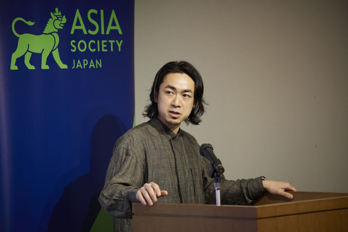Yu Tazawa giving a presentation at the podium