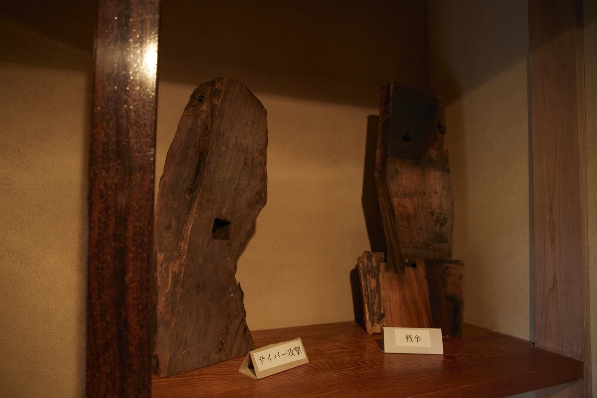 Two shiguchi, traditional joinery, on display with labels, "cyber attach" and "war" in front of each