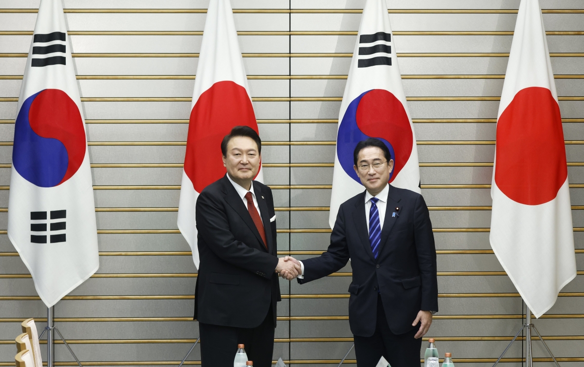 Yoon Suk Yeol, South Korea's president, left, and Fumio Kishida, Japan's prime minister, shake hands ahead of a summit meeting in 2023