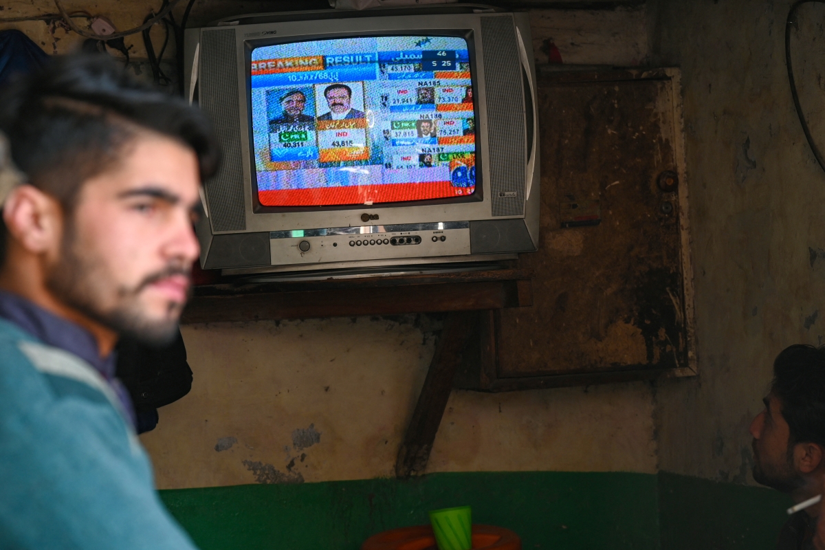 People monitor latest election results live on a television at a tea shop, a day after Pakistan's national elections in Lahore on February 9, 2024. Candidates linked to jailed former Pakistan prime minister Imran Khan were running a close race with the party of three-time premier Nawaz Sharif on February 9 as election results trickled in after a long delay that added to accusations of poll rigging.