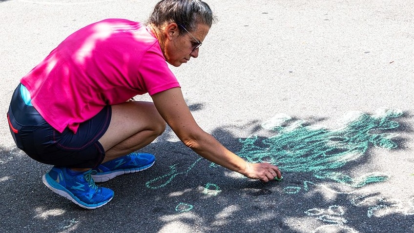 Person making chalk drawing on pavement