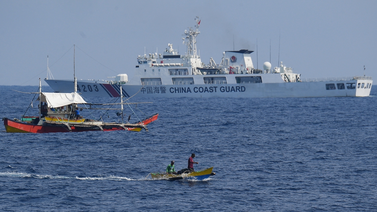 A China Coast Guard ship monitors Philippine fishermen
