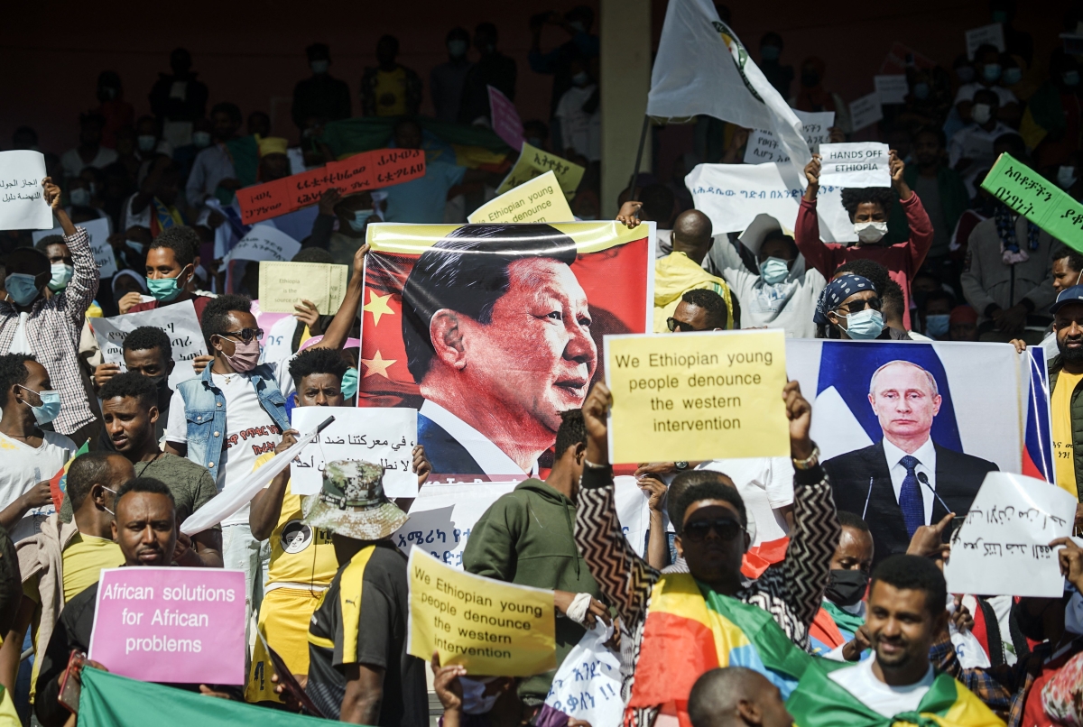 Protesters hold the portraits of China's President Xi Jinping (and Russia's President Vladimir Putin among their messages during a massive rally