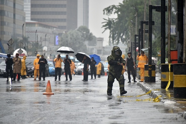Indonesian bomb squad police clear the area as they examine a suspicious box on a main road sidewalk in Jakarta on February 4, 2016. (BAY ISMOYO/AFP/Getty Images)