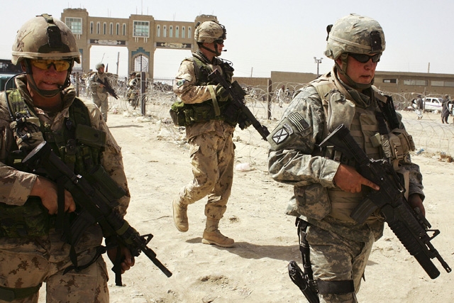 American, (R), and Canadian soldiers walk near the Afghan-Pakistan border crossing in support of Operation Mountain Thrust on June 19, 2006 at Spin Boldak, Afghanistan. (Photo by John Moore/Getty Images)