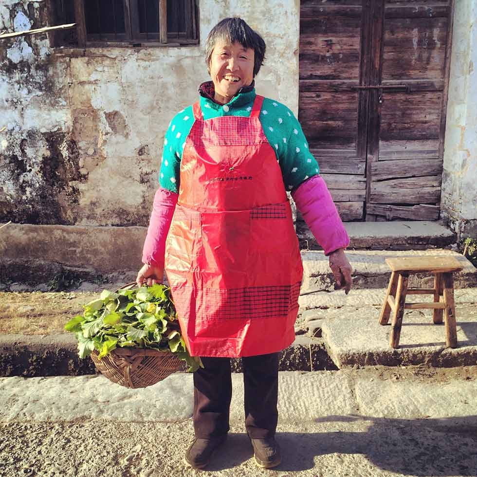 Auntie Wang, a Bishan local farmer, with a basket of daikon leaf. She picked the leaves to give to Ou Ning’s mother. (Sun Yunfan)