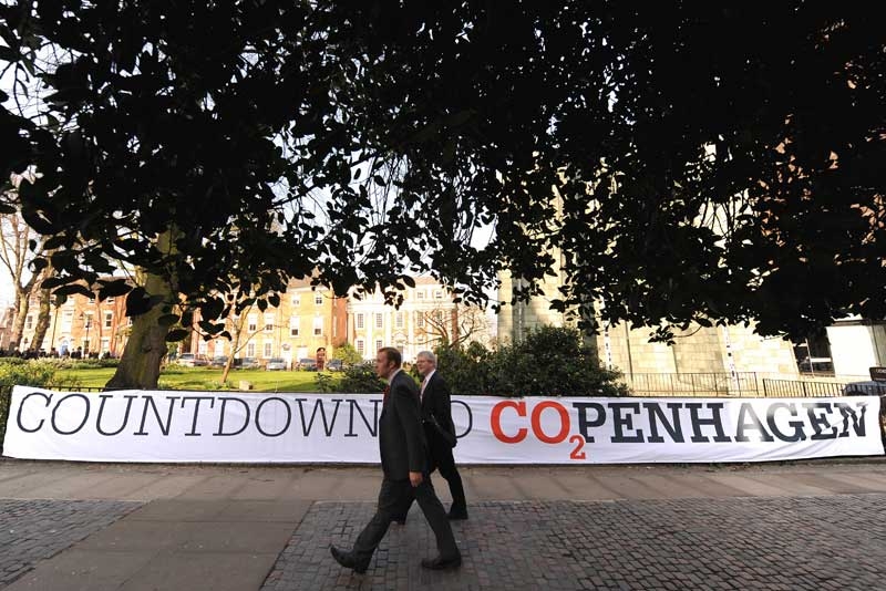 People walk past a banner reading 'Countdown to Copenhagen' during a protest organised by Christian Aid in Coventry, West Midlands on March 19, 2009. (Carl de Souza/AFP/Getty Images)