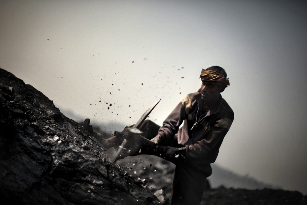 A miner breaks up a large piece of coal. (Erik Messori)