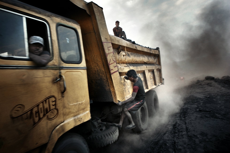 Teenagers jump onto moving trucks, risking their lives to steal a few lumps of coal for the black market. (Erik Messori)
