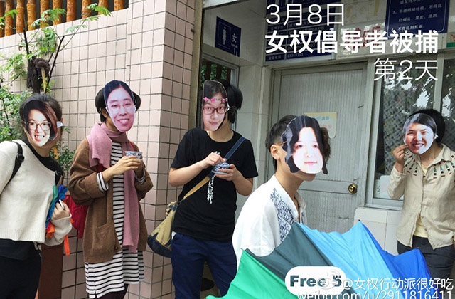 Masked activists pose in front of a public restroom to commemorate the "Occupy Men's Room" movement that several of the detained feminists organized in 2012.