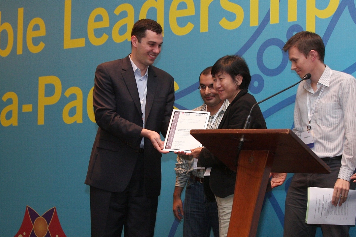 HOME President Bridget Tan receives her award from Asia 21 Fellows John Ciorciari, Soofian Zuberi, and Gregory Fox