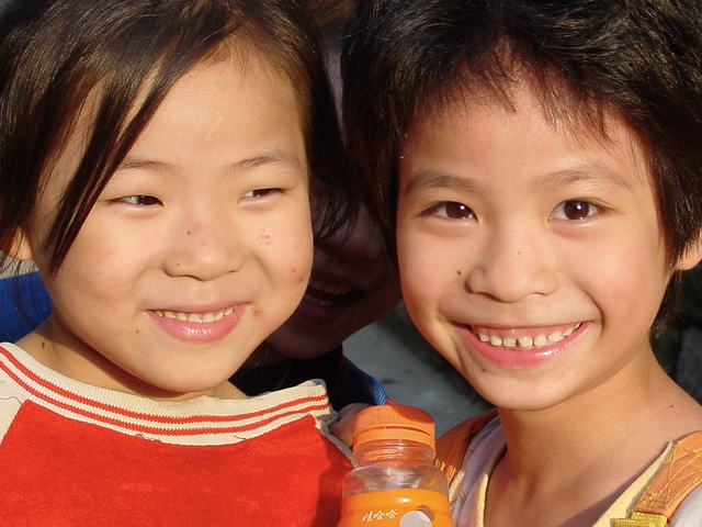 Two children smiling. (Planet Love/flickr)