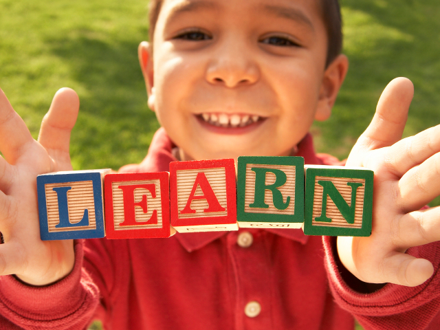 A child with blocks spelling LEARN. (marsbars/istockphoto)