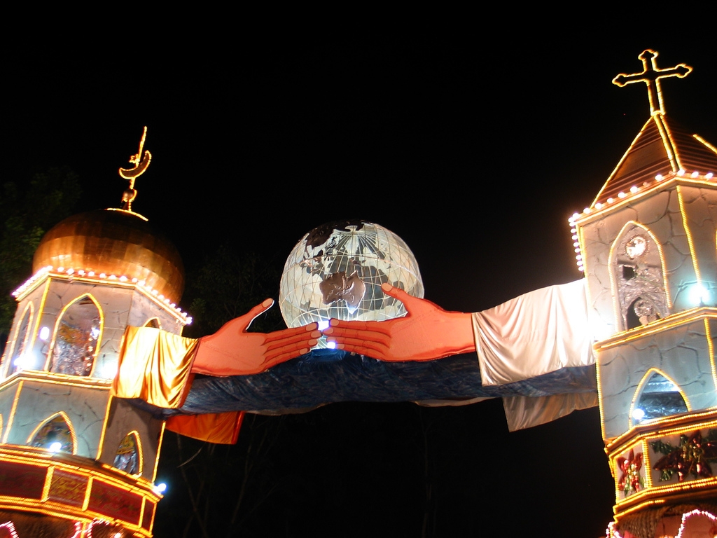 This is a Christmas structure in Naawan, a lively town in Misamis Oriental in the Philippines. it depicts a mosque (crescent) and a church (cross), with two hands reaching out to each other and holding the whole world. (Mercado/Flickr)