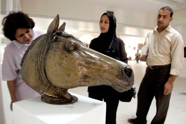 Iraqi artist and administrator for 23 years of the of the Baghdad Art Centre, ex-Saddam Arts Centre, Lamia Jassm (L), explains the history of a bronze mold sculpture to visitors September 10, 2006. (Sabah Arar/AFP/Getty Images)