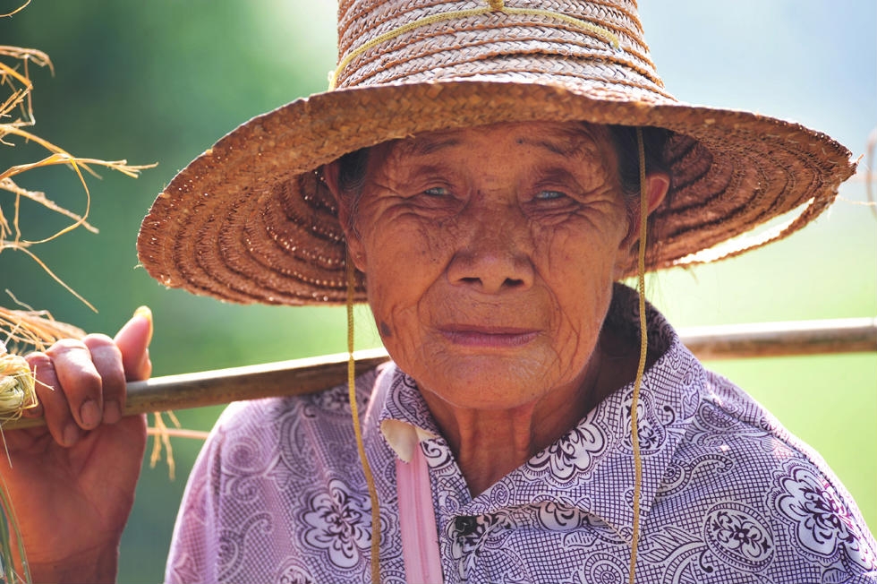 Old Balinese Farmer With Wrinkled Face In Traditional Straw Hat