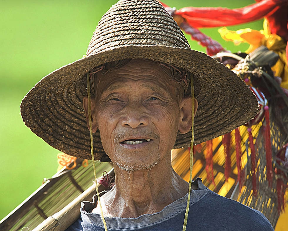 Old Balinese Farmer With Wrinkled Face In Traditional Straw Hat