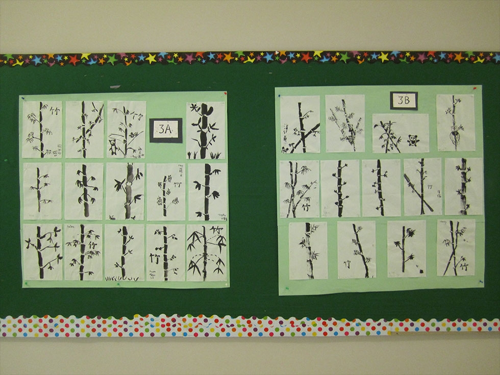 Brush paintings of bamboo by 3rd graders hanging in the hallway.