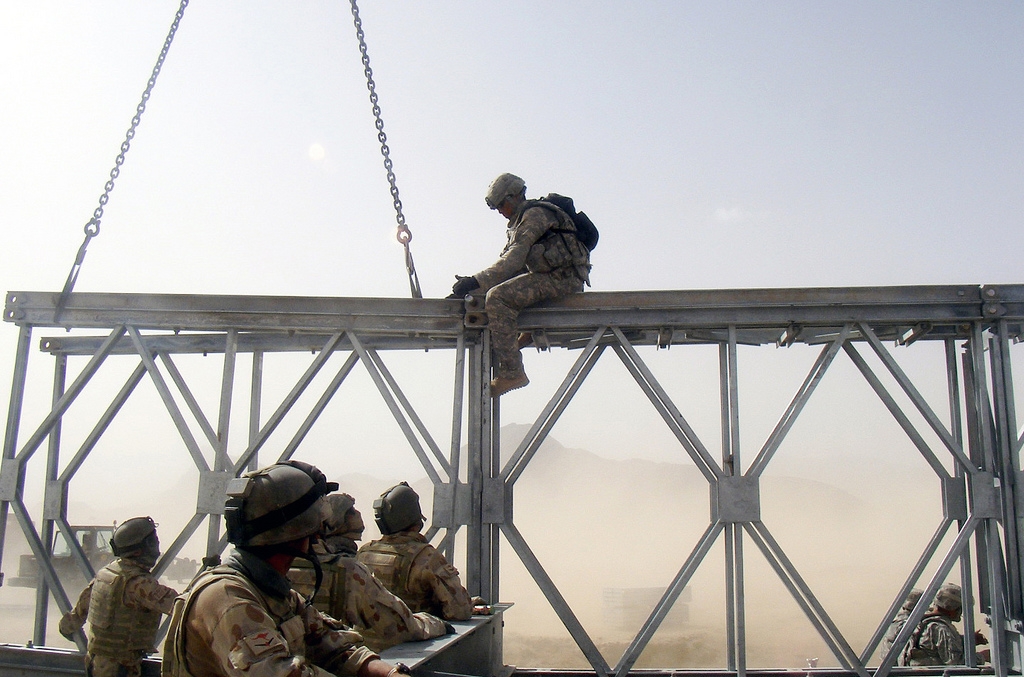 Spc. Corey Thompson, 420th Engineer Brigade, works with Australian combat engineers as they align two sections of a bridge. (Capt. James Reid/Flickr)