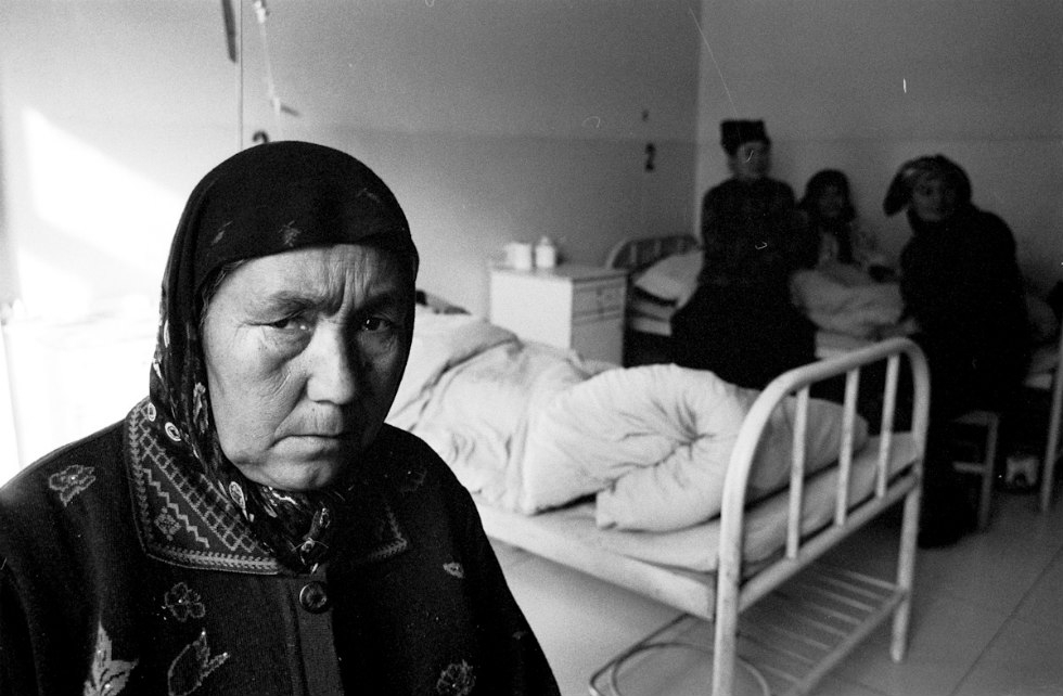 A cataract patient sits in her hospital room before her surgery in Khotan. (Ryan Pyle)