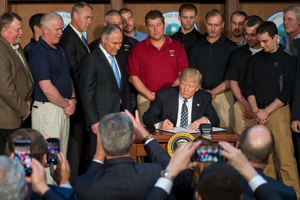 Surrounded by miners from Rosebud Mining, US President Donald Trump (C) signs the Energy Independence Executive Order at the Environmental Protection Agency (EPA) Headquarters in Washington, DC, March 28, 2017. (Jim Watson/AFP/Getty Images)