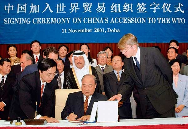 November 11, 2001, Shi Guangsheng, the then Chinese Minister of Foreign Trade and Economic Cooperation, signing the protocol on China’s accession to the WTO in Doha, Qatar. / Photo by Xinhua