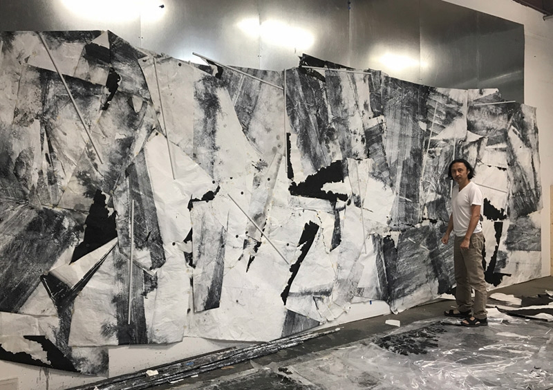 Artist in his studio with 'Tracing the Undulating Contours,' 2017, (ink, acrylic, Xuan paper).  