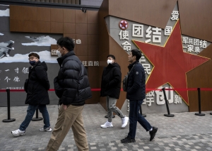 People walk by a large red star that is part of a display at a shopping area on November 15, 2023 in Beijing, China.