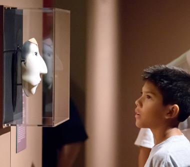 Boy looking at mask at Asia Society Texas in Houston