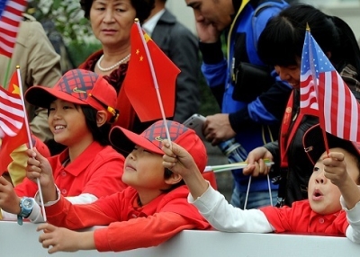 Chinese children wave their national flag together with the US flags in central China's Henan province on October 29, 2012. (Getty Images)