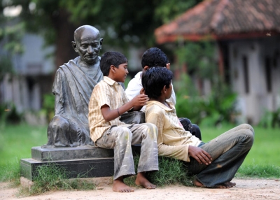 Indian boys sitting on the Mahatma Gandhi statue at the Gandhi Ashram in Ahmedabad in Aug. 2009. (Sam Panthaky/AFP/Getty Images)