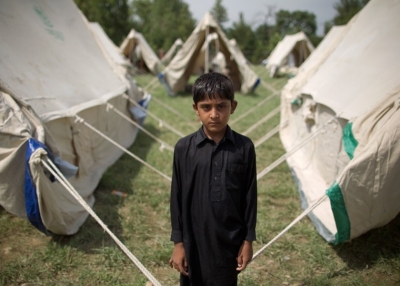 A boy who gave his name as Jeeshan stands outside his tent in a camp set up by the Pakistani army inside a college on the outskirts of Nowshera on August 2, 2010. (Behrouz Mehri/AFP/Getty Images)
