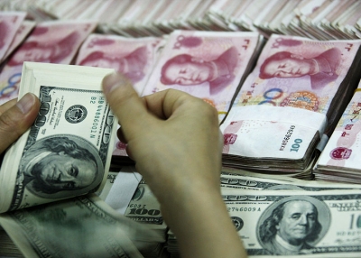 A bank clerk counts a stack of US dollars together with stacks of 100 yuan notes at a bank in Huaibei, China on May 20, 2010. (AFP/AFP/Getty Images) 