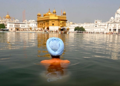 An Indian Sikh devotee takes a dip in the holy sarover (water tank) at the Sikh Shrine Golden Temple in Amritsar on November 5, 2010.
