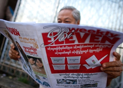 A man reads a newspaper promoting elections on November 5, 2010 in Yangon, Burma. (CKN/Getty Images)