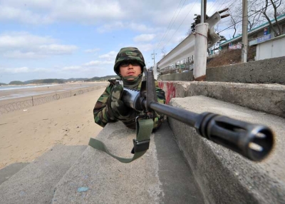 A South Korean soldier stands guard as others prepare for landing operations on a beach in Taean, around 170 km southwest of Seoul on November 28, 2010. The US and South Korea staged a potent show of naval strength as residents of a border island bombarded last week by North Korea scurried for shelter for fear of a new attack. (Jung Yeon-Je/AFP/Getty Images) 