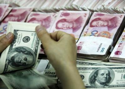 A bank clerk counts a stack of U.S and Chinese bills at a bank in Huaibei, in eastern China's Anhui province, on May 20, 2010. (AFP/AFP/Getty Images)