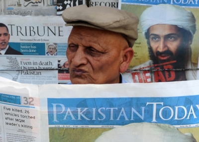 A Pakistani man reads a newspaper with the front page displaying news of the death of Osama bin Laden at a stall in Lahore on May 3, 2011. (Arif Ali/AFP/Getty Images)