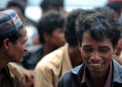 A Rohingya Muslim from Myanmar, who tried to cross the Naf river into Bangladesh to escape sectarian violence, reacts while kept under watch by Bangladeshi security officials after disembarking from an intercepted boat in Teknaf on June 18, 2012. (Munir Uz Zaman/ AFP/GettyImages)