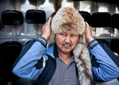 A Kyrgyz fur hat seller adjusts his headgear as he poses for a portrait. (Sue Anne Tay)