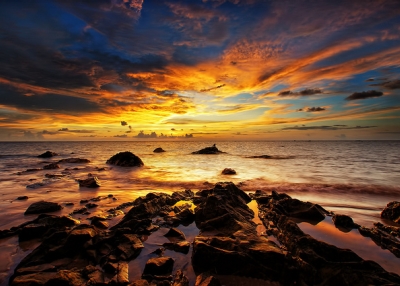 The sun sets over the rocky waters in Labuan, Malaysia on May 28, 2012. (SaturatedEyes/Flickr)